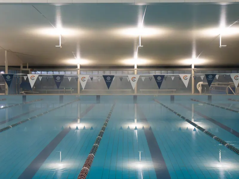 The heated indoor pool lit from above, with pennants strung across the lanes